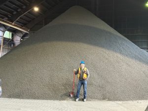 Photo of Bulk Sample at Stewart Bulk Terminal awaiting transport. Product has been crushed to ½" minus. Scottie COO Sean Masse for scale.